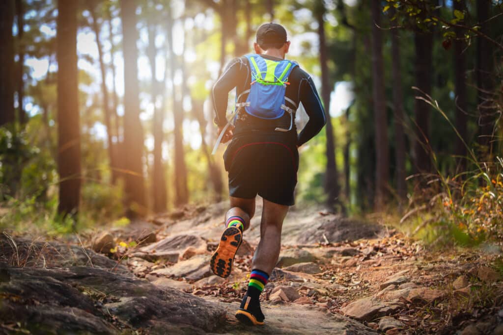 A man Runner of Trail . and athlete's feet wearing sports shoes for trail running in the forest